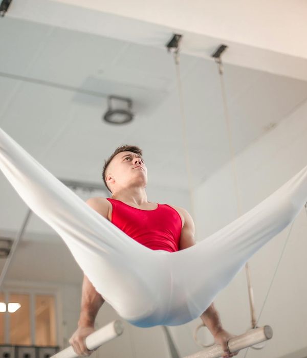 Man performing a controlled strength exercise in a dark gym environment.